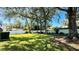 Expansive backyard featuring a lush lawn, mature trees offering shade, and a well-maintained white fence enhancing privacy at 6206 Soaring Ave, Temple Terrace, FL 33617