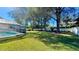 Lush backyard featuring healthy lawn, tall trees, fence, and a screened-in patio at 6206 Soaring Ave, Temple Terrace, FL 33617