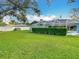 Large backyard with lush grass, a screened pool, and a privacy fence at 6206 Soaring Ave, Temple Terrace, FL 33617