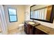 Bathroom featuring a custom vanity with granite countertop, decorative mirror, and tiled floors at 6206 Soaring Ave, Temple Terrace, FL 33617