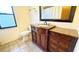 Bathroom featuring a custom vanity with granite countertop, decorative mirror, and tiled floors at 6206 Soaring Ave, Temple Terrace, FL 33617