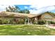 Charming brick home featuring a well-manicured lawn, mature landscaping, and decorative fountain at 6206 Soaring Ave, Temple Terrace, FL 33617