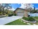 Charming home featuring a brick facade, manicured landscaping, and a two-car garage with an extended driveway at 6206 Soaring Ave, Temple Terrace, FL 33617