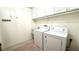 Convenient laundry room with white cabinets, appliances, utility sink, and decorative floor mat at 6206 Soaring Ave, Temple Terrace, FL 33617