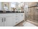 Bathroom with double vanity, granite countertops, and tiled shower at 10595 Marsha Dr, New Port Richey, FL 34655