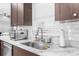 Clean kitchen with stainless steel sink, marble countertop and white tile backsplash at 13031 Pacific Nighthawk Ave, Weeki Wachee, FL 34614