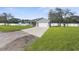 Front view of a single-story house with a driveway and fenced yard at 13031 Pacific Nighthawk Ave, Weeki Wachee, FL 34614