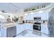 Modern kitchen with white cabinets, stainless steel appliances, and granite countertops at 8704 Cypress Lakes Blvd, New Port Richey, FL 34653