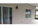 Back patio detail featuring a sliding glass door, window, and exterior light at 6109 School House Ct, Wesley Chapel, FL 33545