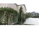 Side yard with landscaping, white fence, and a view of a neighboring garage at 6109 School House Ct, Wesley Chapel, FL 33545