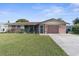 Brick ranch home with attached garage and landscaped yard at 10316 Amadeus Dr, Port Richey, FL 34668