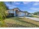 Tan house exterior with a teal door, stone path, and two-car garage at 13360 Wrenwood Cir, Hudson, FL 34669