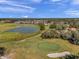 Aerial view of a golf course with a putting green and golf carts at 13360 Wrenwood Cir, Hudson, FL 34669