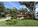 Tan house with brown roof, attached garage, and spacious lawn at 15473 Darien Way, Clearwater, FL 33764