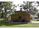 Side view of tan house, AC unit, and storage bins at 15473 Darien Way, Clearwater, FL 33764