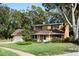 Tan house with brown roof, attached garage, and spacious lawn at 15473 Darien Way, Clearwater, FL 33764