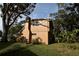 Tan house exterior with a chimney and large trees in the yard at 15473 Darien Way, Clearwater, FL 33764