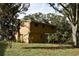 Back of tan house with sliding glass door and yard at 15473 Darien Way, Clearwater, FL 33764