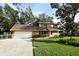 Tan house with brown roof and attached garage, ample yard space at 15473 Darien Way, Clearwater, FL 33764