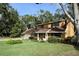 Tan house with brown roof, attached garage, and spacious lawn at 15473 Darien Way, Clearwater, FL 33764