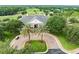 Aerial view of the clubhouse with palm trees, lush landscaping, and a nearby golf course at 6392 Summit View Dr, Brooksville, FL 34601