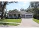 Attractive single-story home showcasing a cozy front porch, well-kept lawn, and an attached two-car garage at 6392 Summit View Dr, Brooksville, FL 34601
