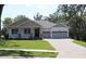 Inviting single-story house featuring a lovely front porch, lush green lawn, and an attached two-car garage at 6392 Summit View Dr, Brooksville, FL 34601