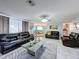 Open living room with leather seating, a coffee table, and a view of the dining area at 7310 Rockwood Dr, Port Richey, FL 34668
