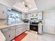 Updated kitchen with light gray cabinets, stainless steel appliances, and a breakfast bar at 7310 Rockwood Dr, Port Richey, FL 34668