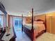 Spacious bedroom with a four-poster bed, dresser, and access to the backyard at 7310 Rockwood Dr, Port Richey, FL 34668