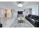 Living room with leather sofas, a large TV, and tiled floors at 7310 Rockwood Dr, Port Richey, FL 34668