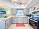 Updated kitchen with light gray cabinets, stainless steel appliances, and a breakfast bar at 7310 Rockwood Dr, Port Richey, FL 34668