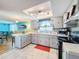 Updated kitchen with light gray cabinets, stainless steel appliances, and a breakfast bar at 7310 Rockwood Dr, Port Richey, FL 34668