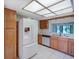 Modern kitchen with white appliances and ample wood cabinetry at 7719 Cosme Dr # 1, Hudson, FL 34667