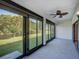 Spacious sunroom has walls of glass with a ceiling fan at 7719 Cosme Dr # 1, Hudson, FL 34667