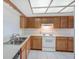 Efficient kitchen featuring wood cabinets, a tiled floor, and modern appliances at 7719 Cosme Dr # 1, Hudson, FL 34667