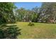 Vacant lot ready for new construction, featuring mature trees and a large, open space at 9305 Kiowa Dr, New Port Richey, FL 34654
