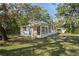 White house with boarded-up front door and large tree at 9305 Kiowa Dr, New Port Richey, FL 34654