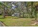 Small white house on a grassy lot with mature trees at 9305 Kiowa Dr, New Port Richey, FL 34654