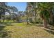 Large backyard with mature trees and a view of the house at 9305 Kiowa Dr, New Port Richey, FL 34654