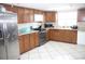 Kitchen with wood cabinets, stainless steel appliances, and tile floor at 7204 Westcott Dr, Port Richey, FL 34668