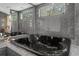 Elegant bathroom featuring a black soaking tub and granite tile at 7222 Auburn Ln, New Port Richey, FL 34654