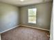 Bright bedroom with carpeted floor and large window at 13069 Maycrest Ave, Weeki Wachee, FL 34614