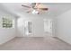 Spacious main bedroom with carpet, ceiling fan and access to bathroom at 13080 Old Crystal River Rd, Brooksville, FL 34601