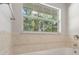 Bathroom with a bathtub and window overlooking trees at 13080 Old Crystal River Rd, Brooksville, FL 34601