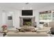 Cozy living room featuring a stone fireplace, flat-screen TV, and backyard views at 13080 Old Crystal River Rd, Brooksville, FL 34601