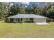 Single story house with metal roof and attached garage at 13080 Old Crystal River Rd, Brooksville, FL 34601