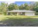Single story house with metal roof, attached garage, and large yard at 13080 Old Crystal River Rd, Brooksville, FL 34601