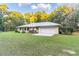 Single story house with metal roof, attached garage, and large yard at 13080 Old Crystal River Rd, Brooksville, FL 34601