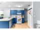 Kitchen with blue cabinets, white appliances and an open floor plan at 13242 Little Farms Dr, Spring Hill, FL 34609